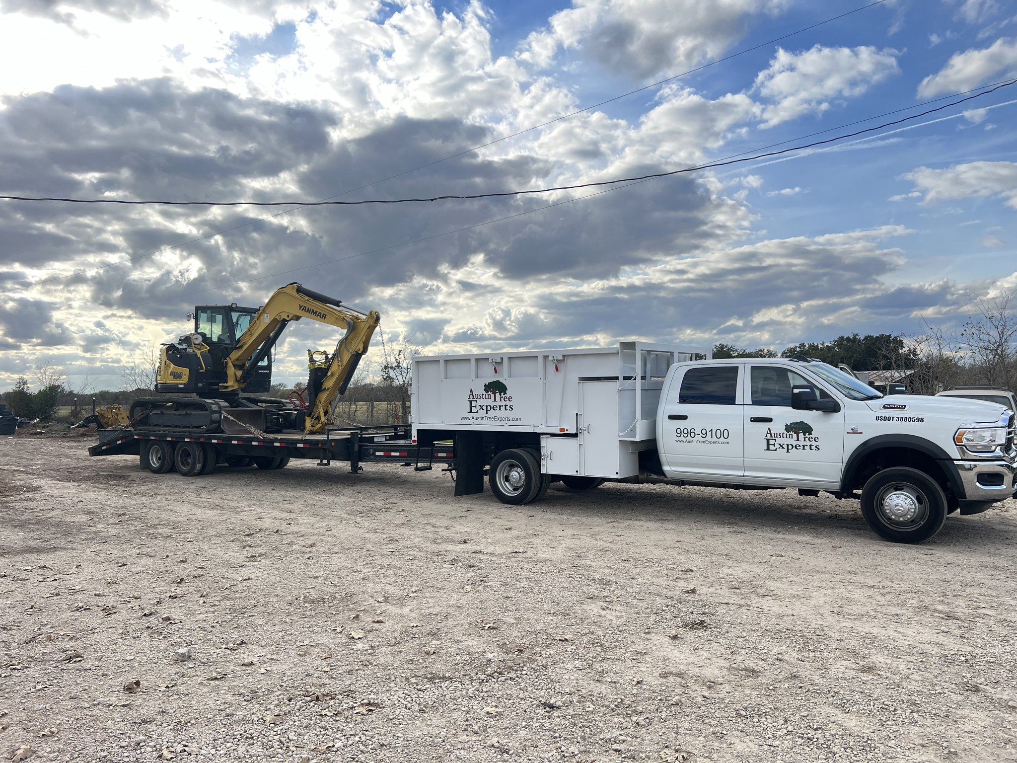 Truck and excavator on trailer for fuel break clearing in Central Texas