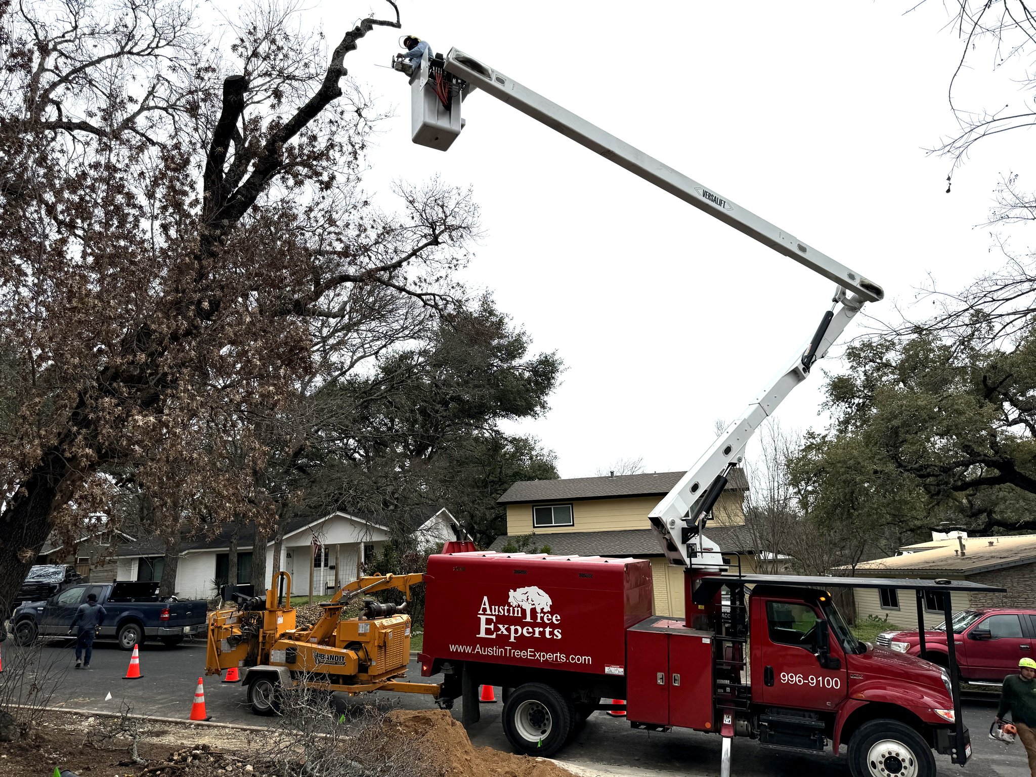 Austin Tree Experts bucket truck performing tree removal in residential neighborhood